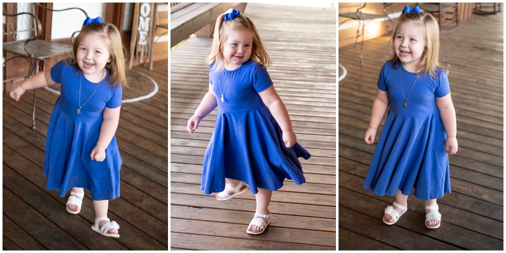 little girl in blue dress twirling on the porch