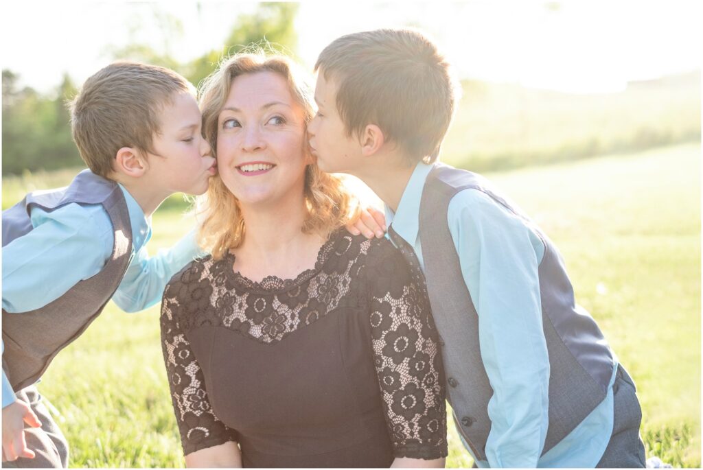 two boys giving their mommy a kiss on the cheek