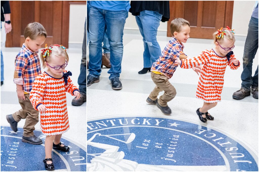 two kids on adoption day chasing each other around the seal