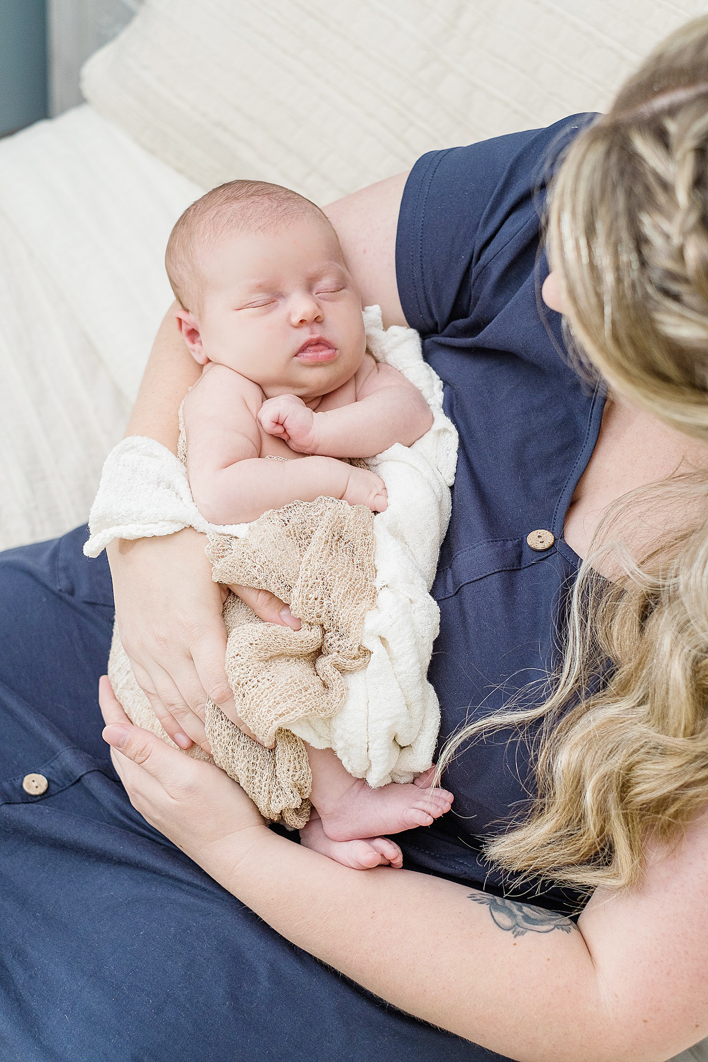 mother holding newborn in lifestyle family session