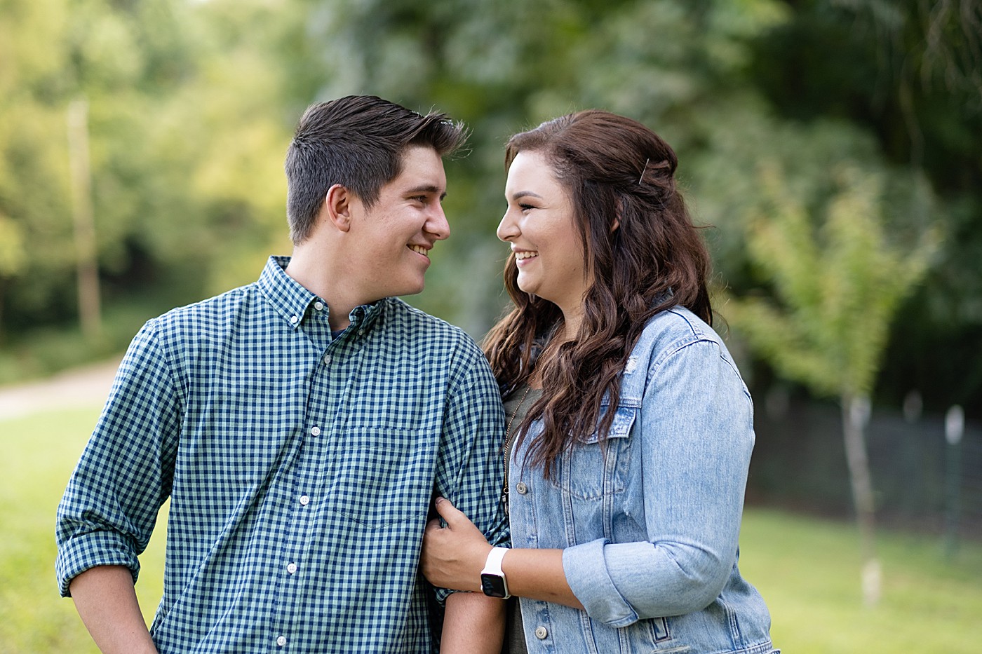 man and woman smiling at each other during their engagement portraits