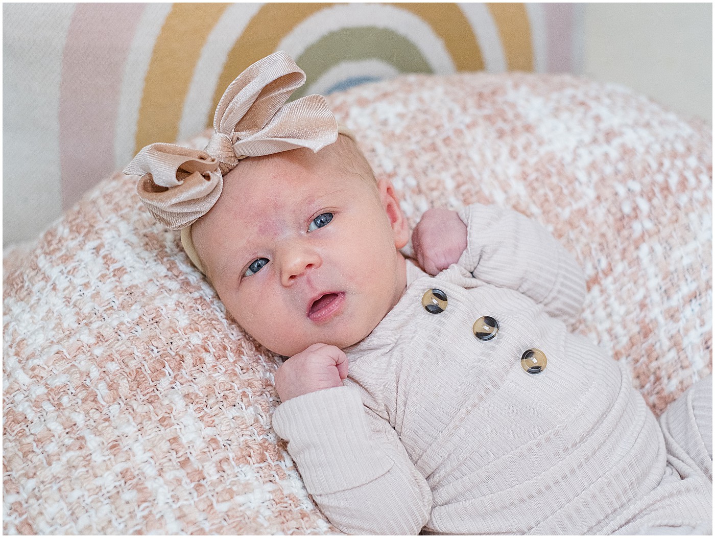 rainbow pillow behind newborn because she is a rainbow baby