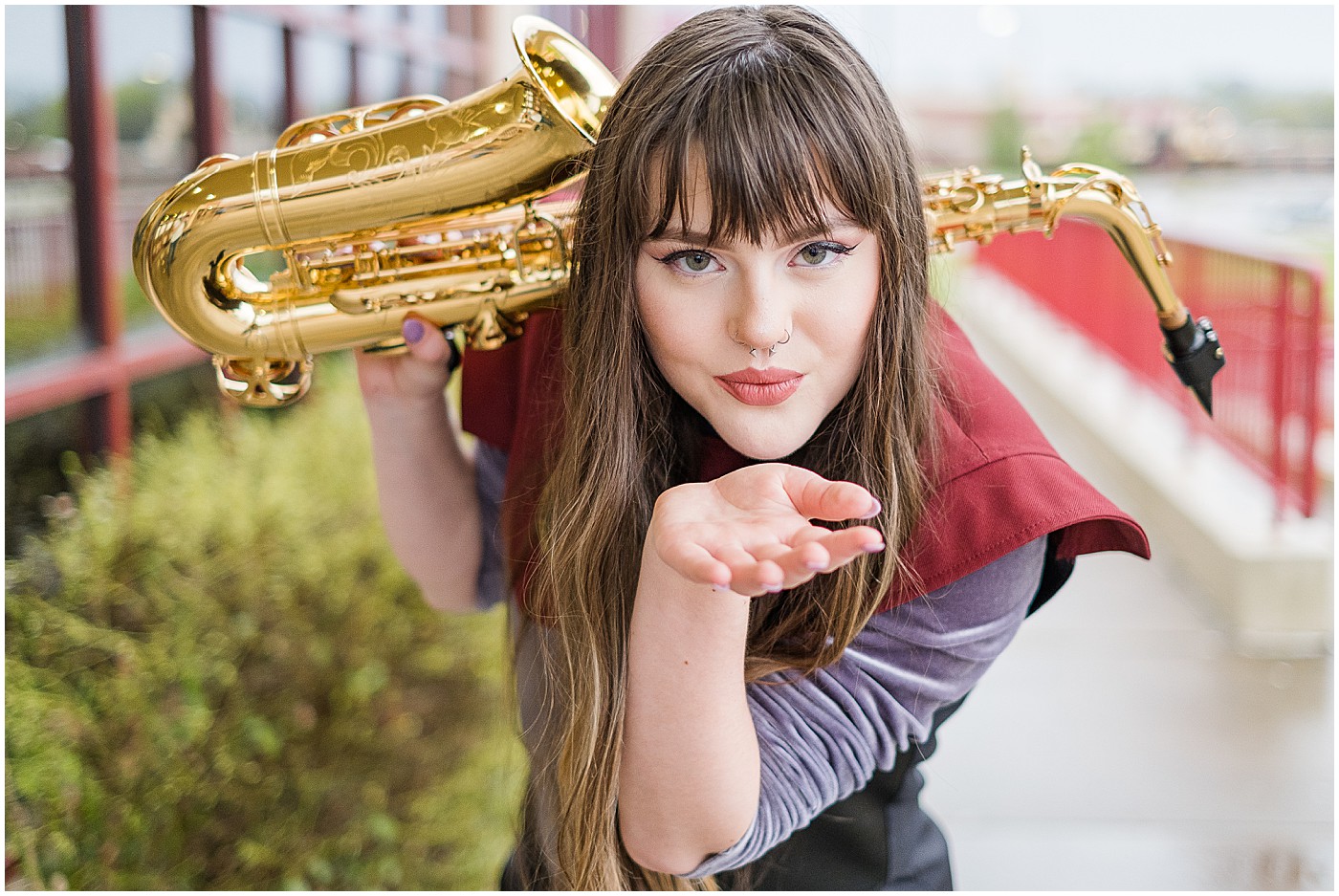 Barren County senior girl holding saxophone and blowing a kiss