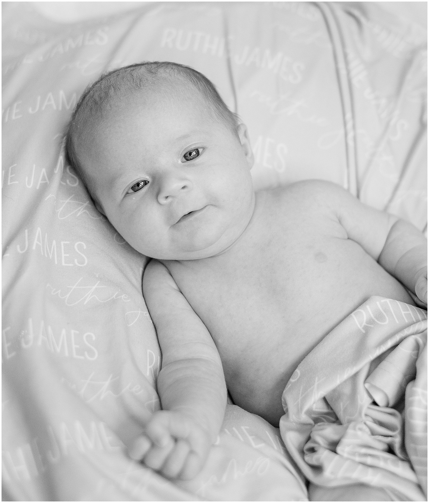 black and white image of baby wrapped in blanket