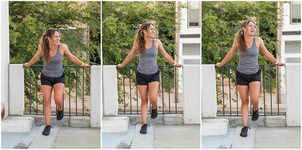 Yvonne in gray tank top and shorts holding on fence and leaning forward to laugh