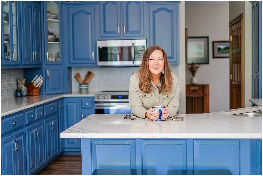 woman leaning on counter in blue kitchen