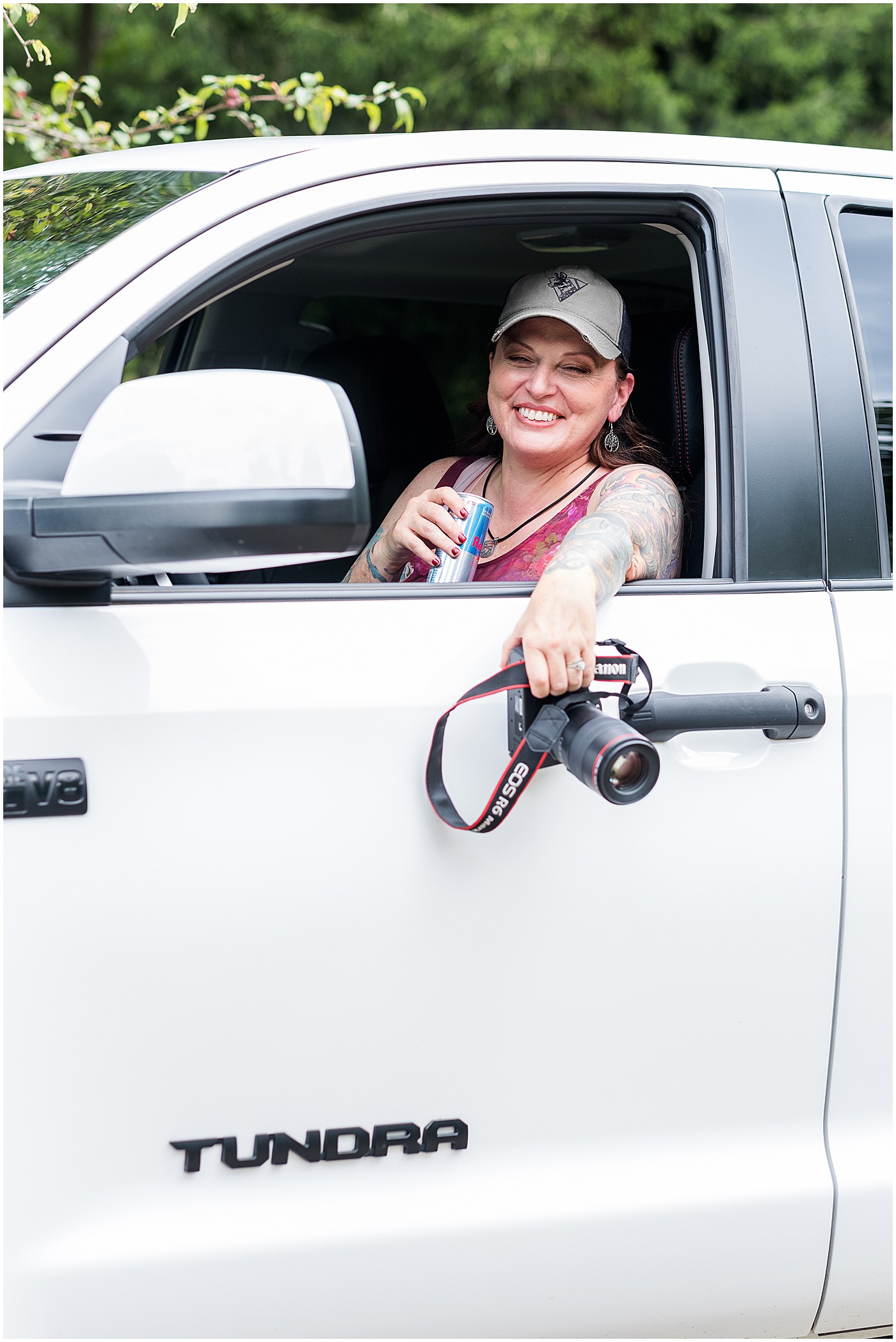 photographer in her truck with camera and a red bull