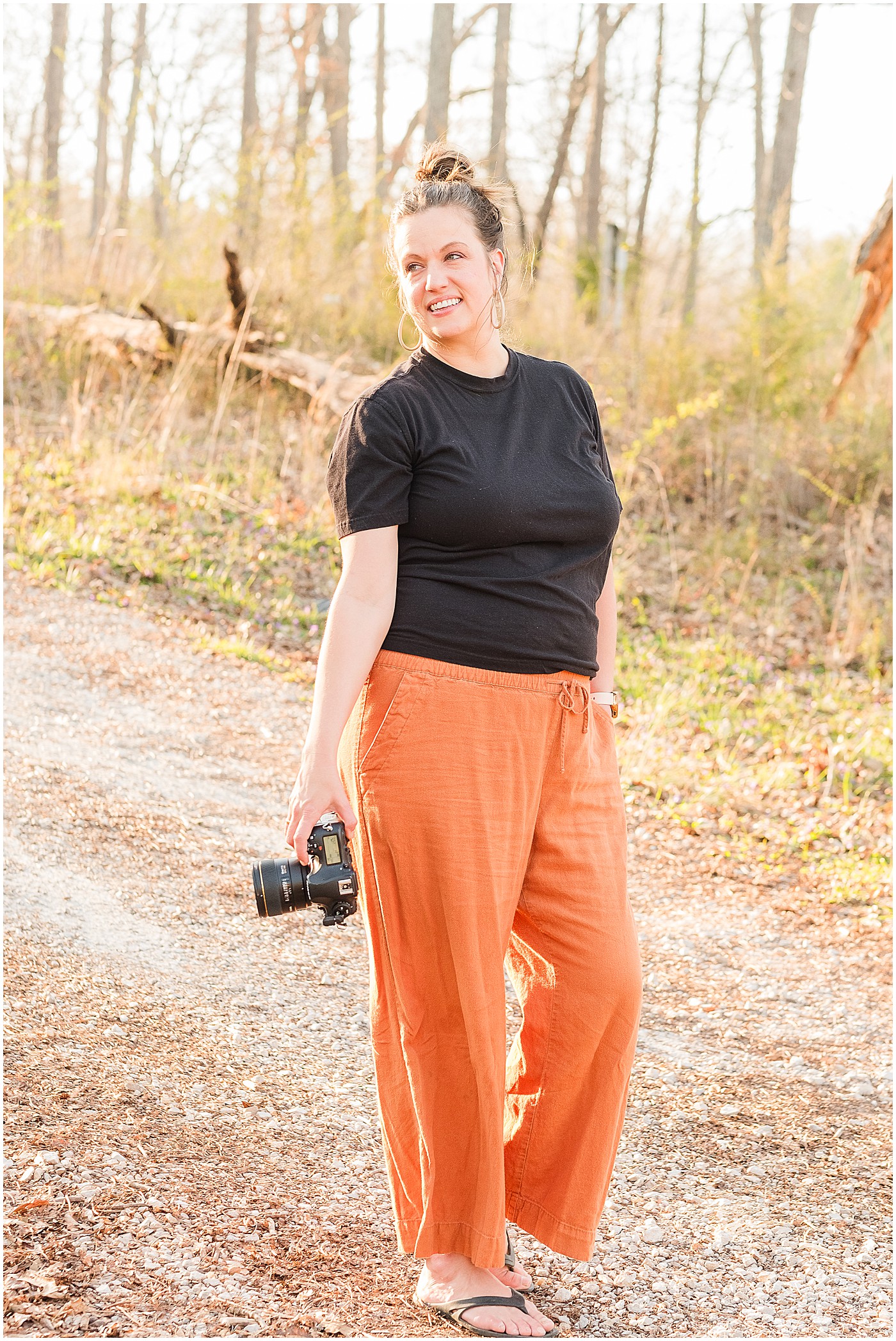 North Carolina photographer in orange pants holding her camera