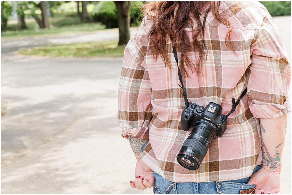 camera slung over the back of a photographer