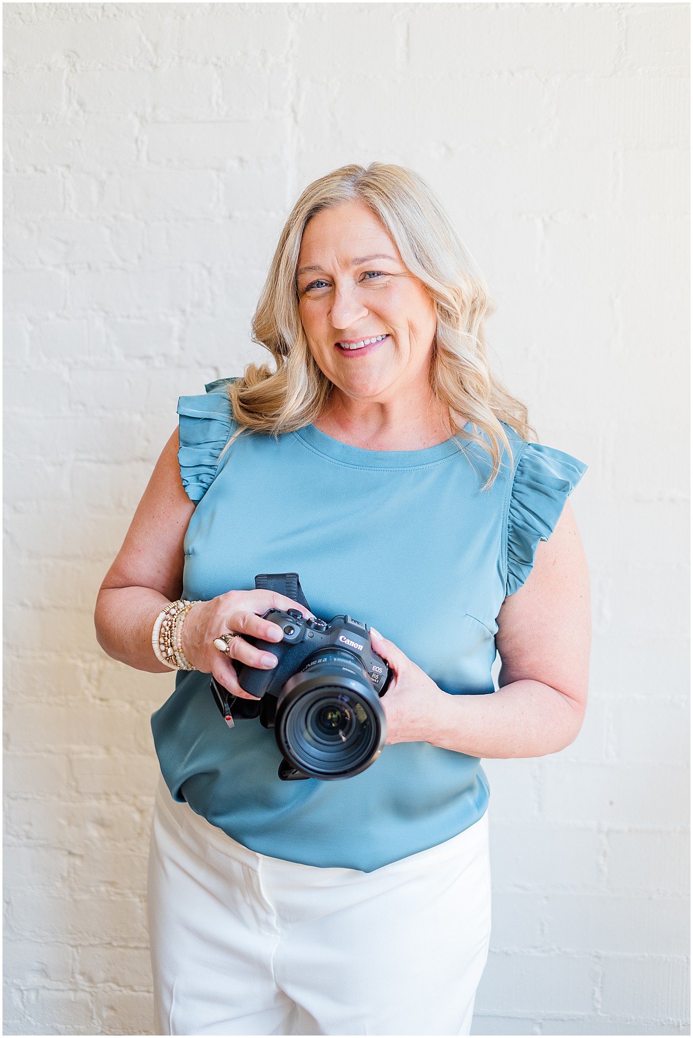 photographer in blue shirt with camera in her hand during photography branding session