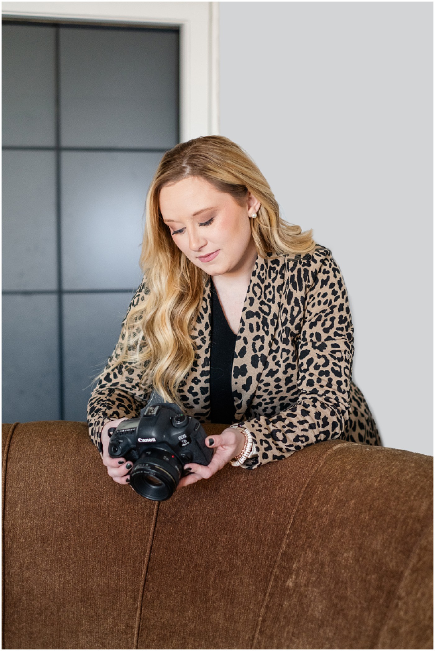 photographer leaning on back of couch looking at the back of her camera