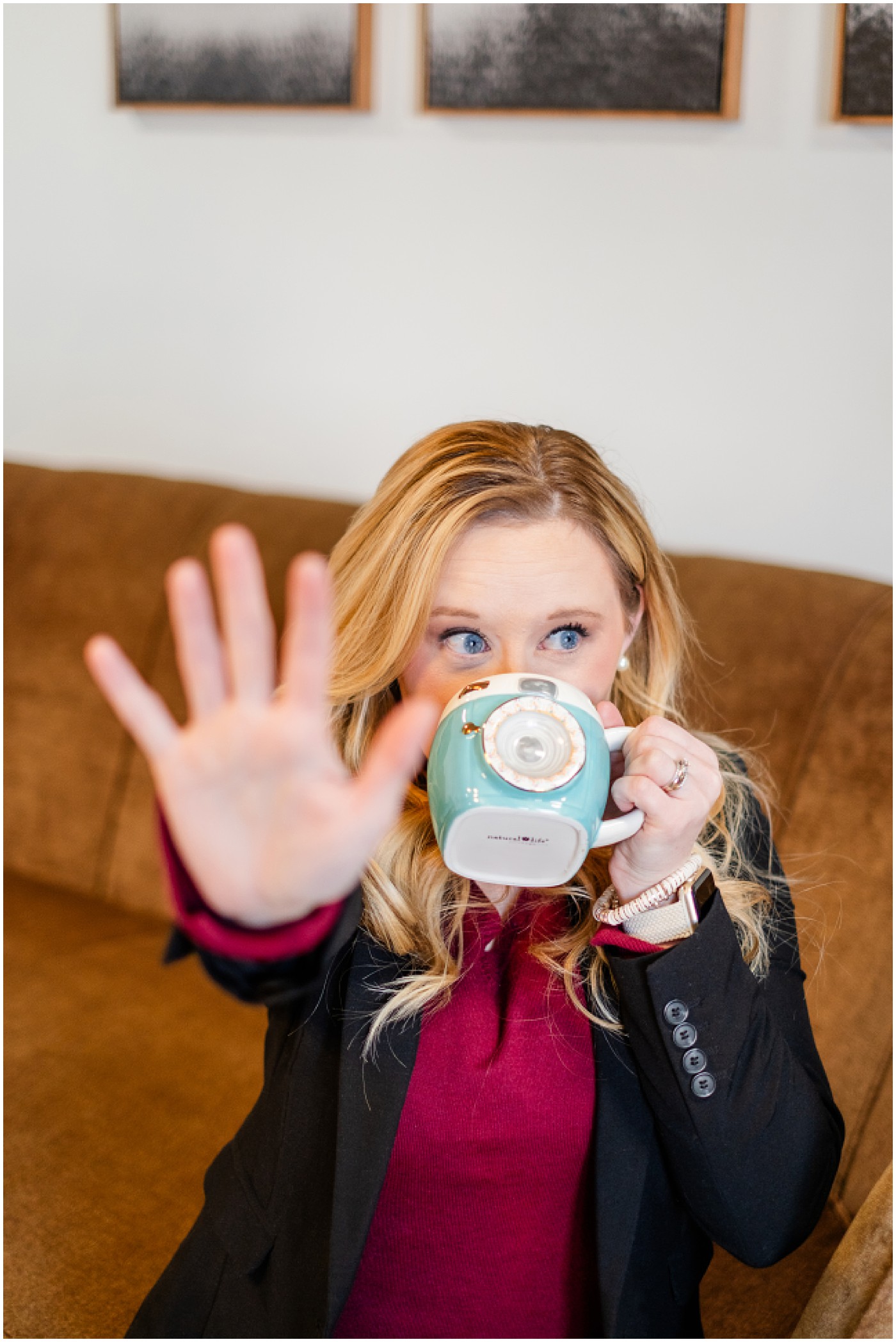 on photography branding session, woman drinking coffee with her hand up to say wait a minute