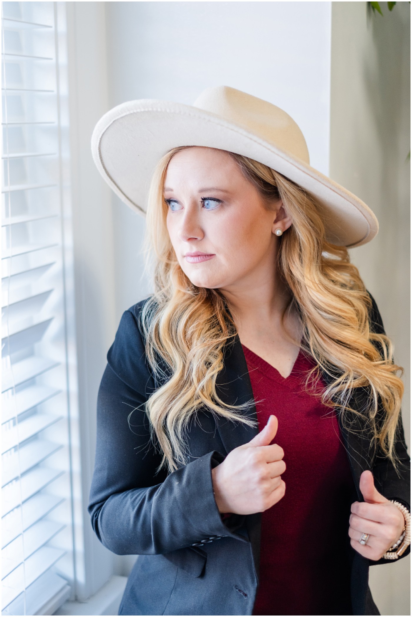 photographer with hat on looking out window