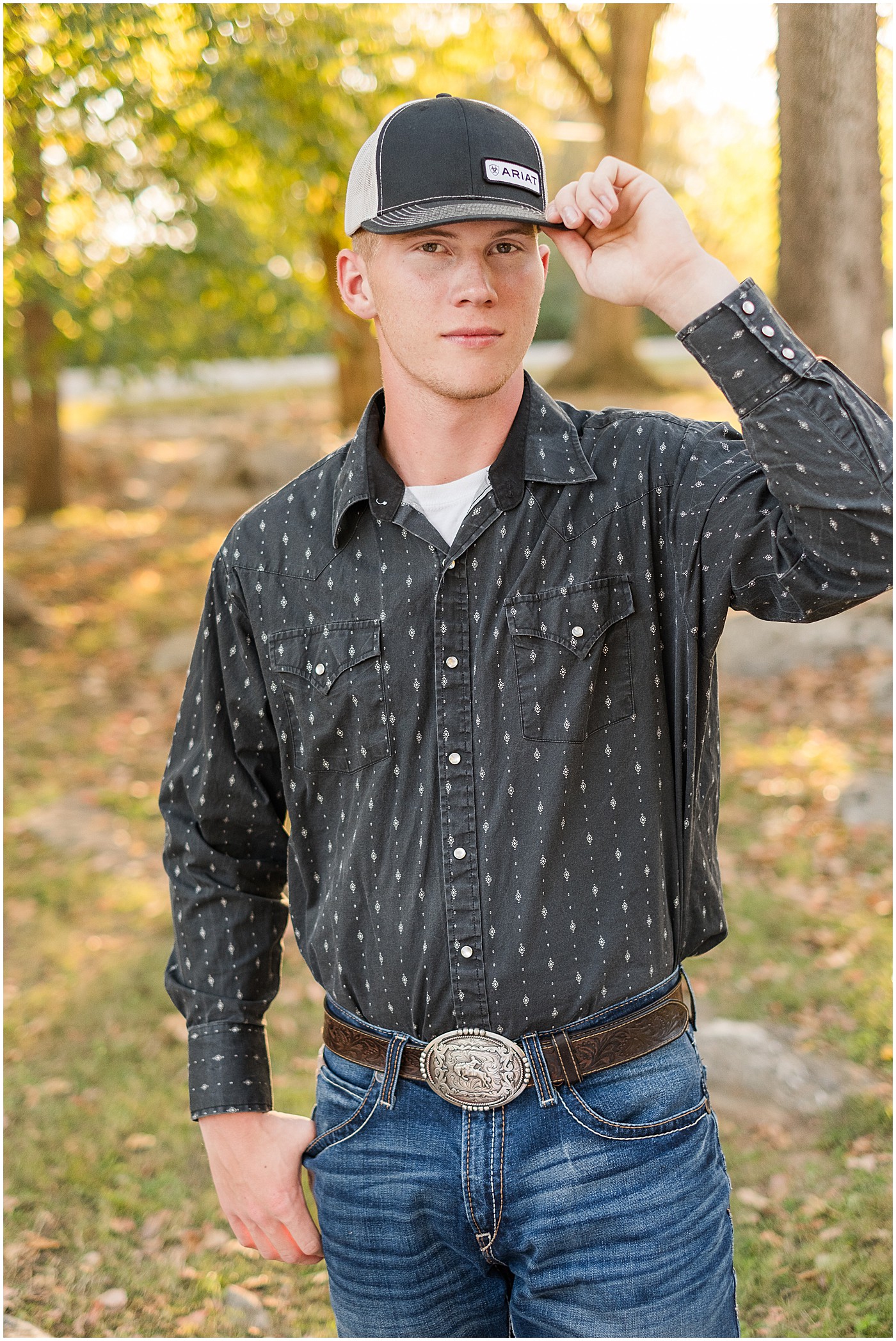 senior boy holding on to his ball cap