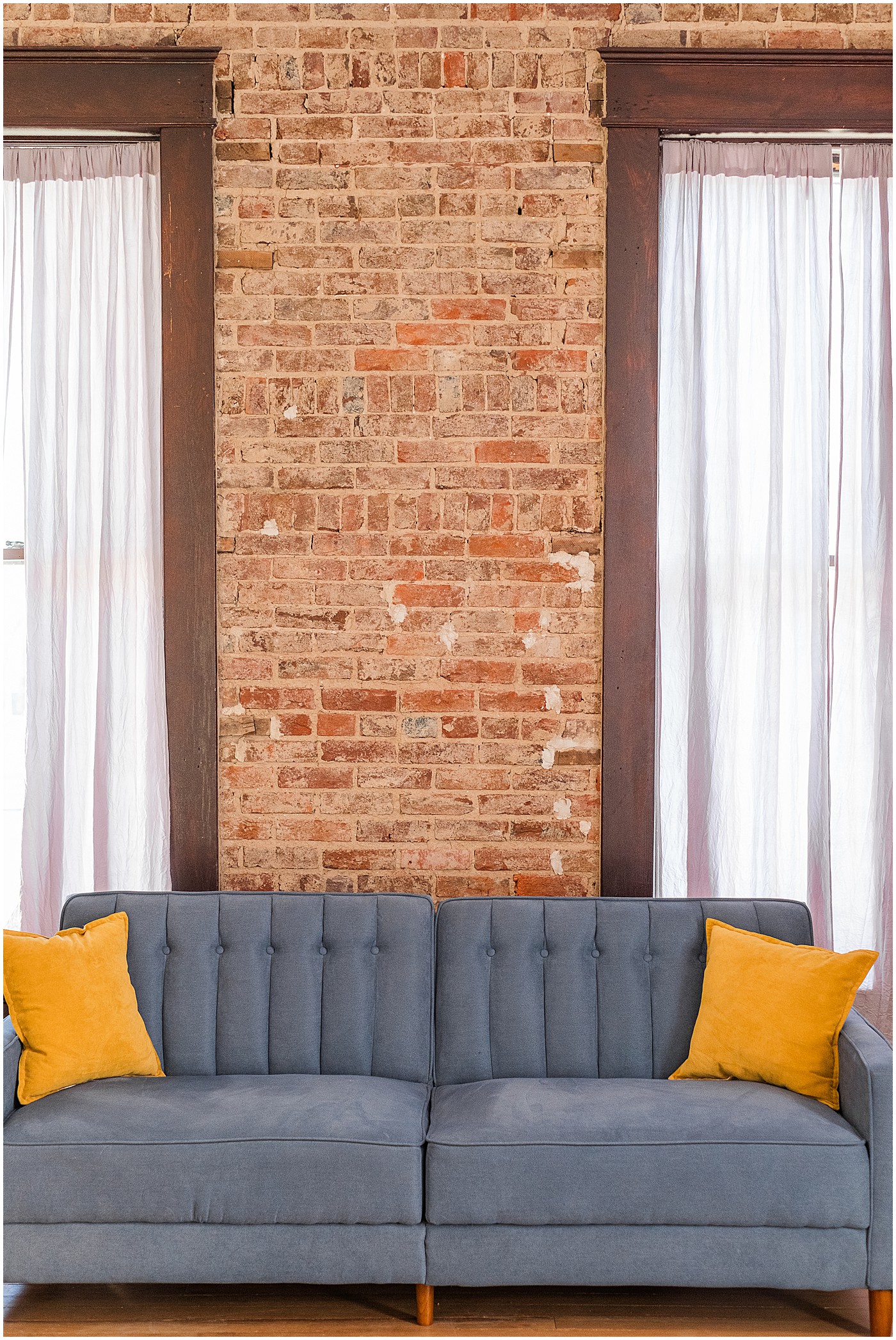 high ceilings and blue couch with yellow pillows in this bowling green branding location