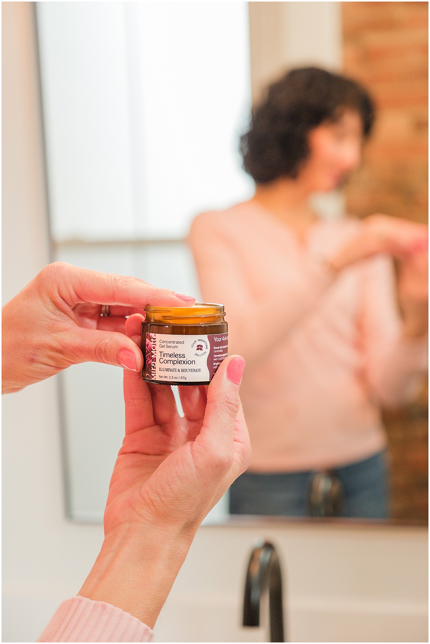 closeup of model holding gel serum called timeless complexion