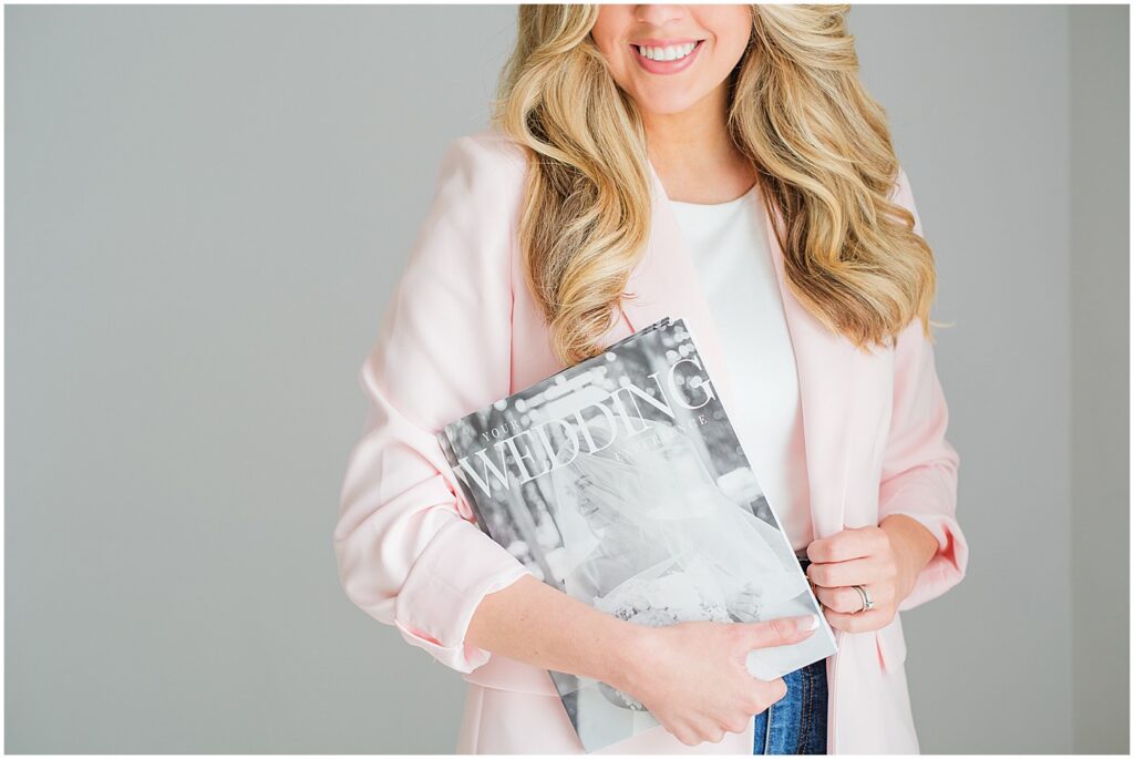wedding photographer branding session with her holding the brochure she sends to each client
