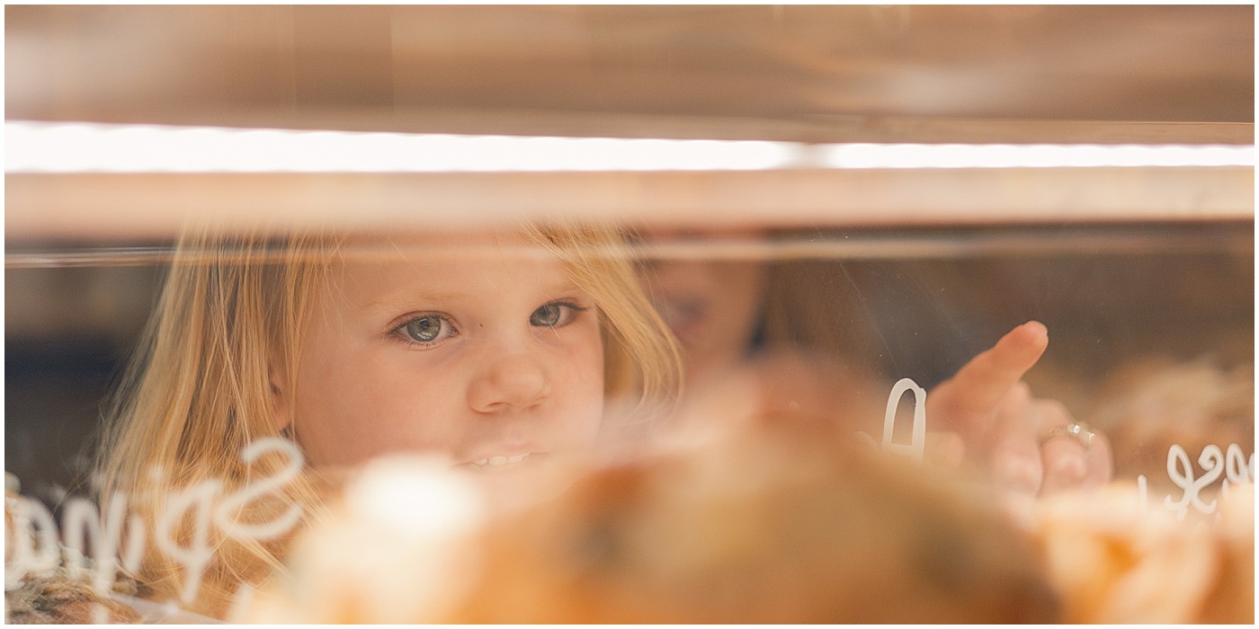 little girl looking in pastry case during coffee shop branding session